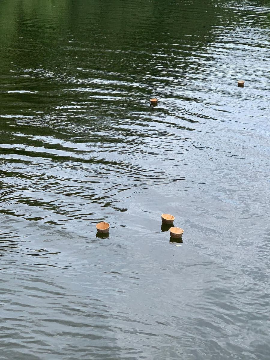 Two biodegradable water urns floating on the Avon