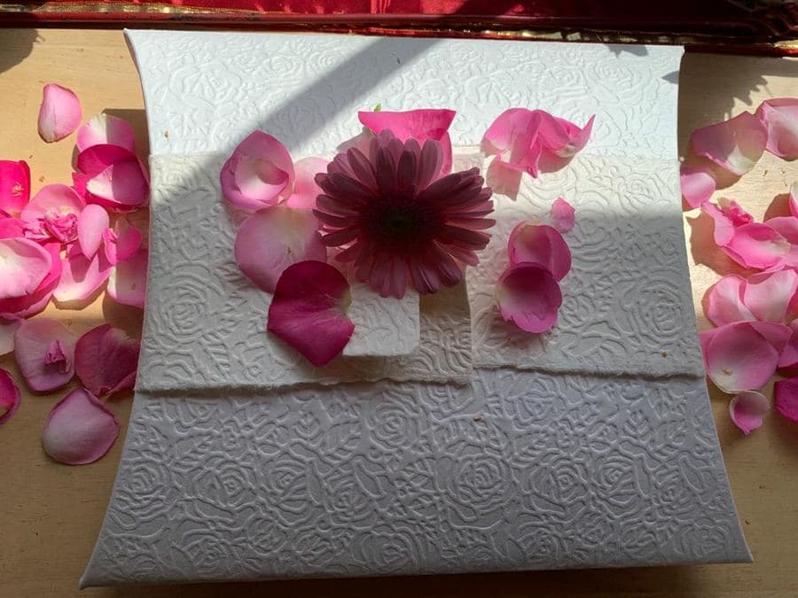 A handmade paper urn with flower petals, ready for the river